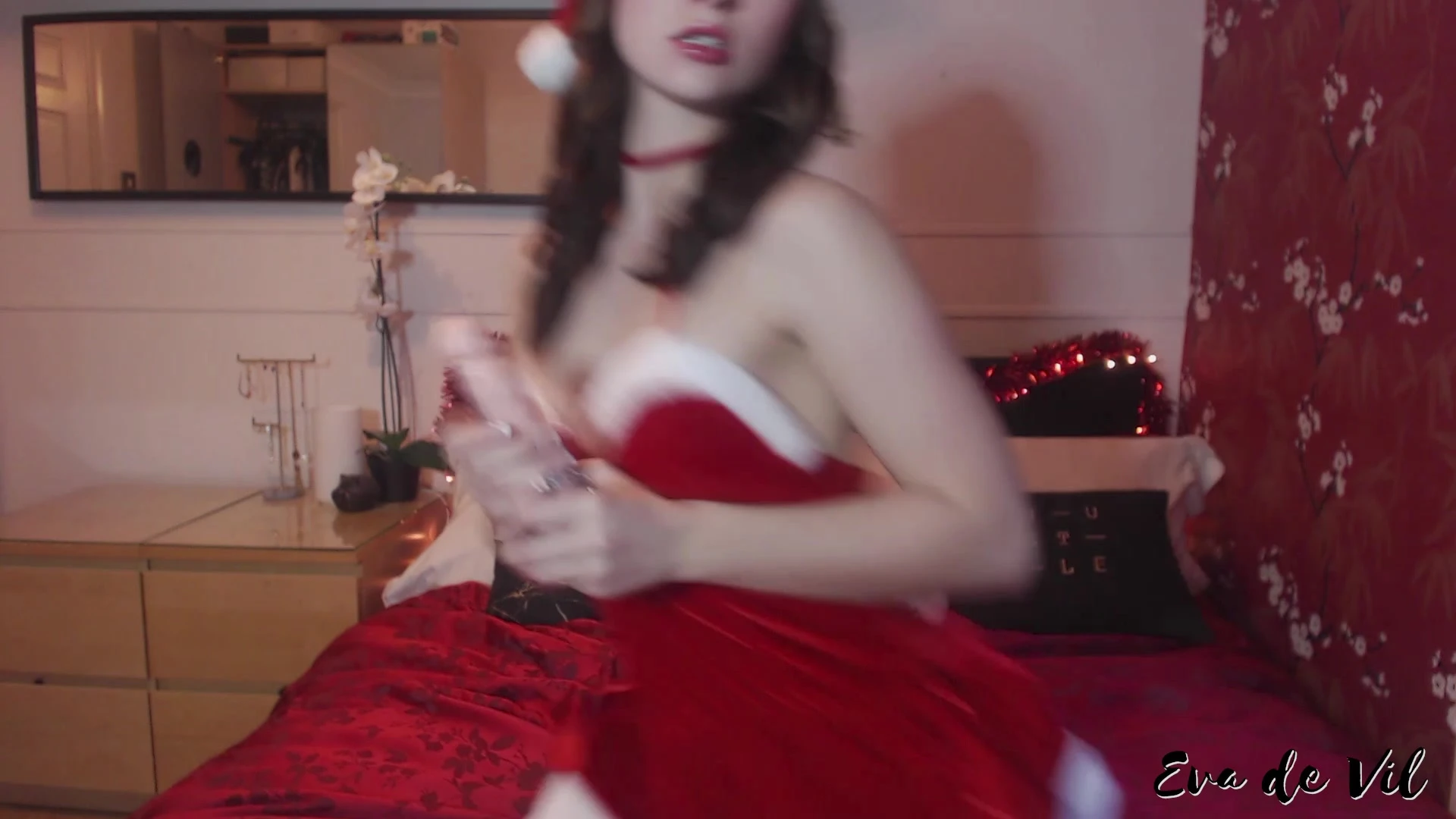 Eva de Vil playing with a dildo in her red christmas gown
