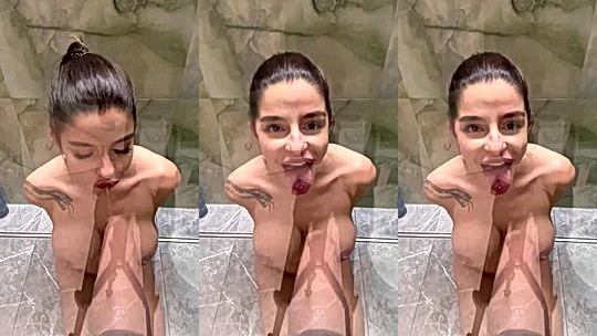 Sonya Jess on her knees sucking on a huge dildo in the shower